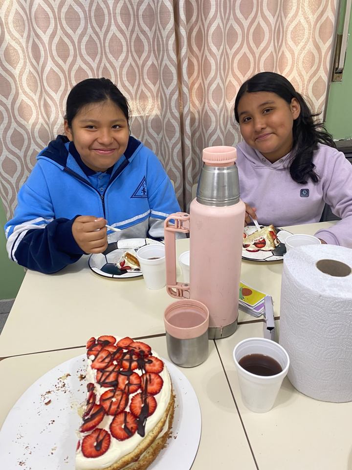 Dos estudiantes comparten la torta de frutillas que prepararon en el taller MasterChef Junior